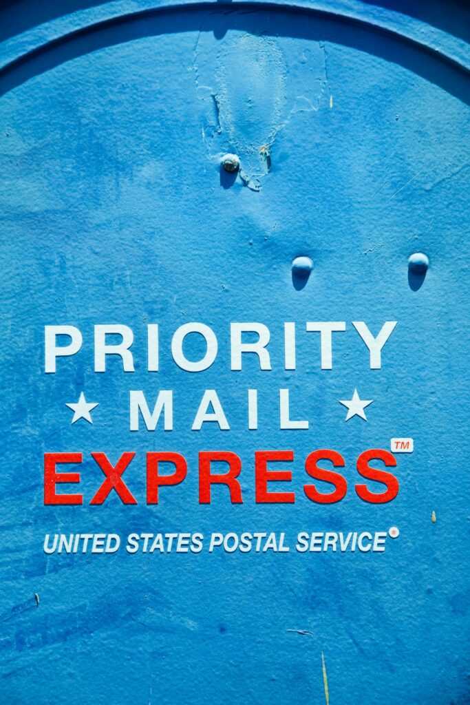 Close-up of a blue USPS mailbox featuring 'Priority Mail Express' text, ideal for postal themes.